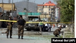 Security forces and medical workers attend the scene of a deadly bomb attack in Kabul in June. 