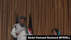 Afghan parliament members Hajji Abdul Basir (left) and Homa Soltani speak at a press conference where they showed the letter signed by Taliban leader Mullah Mohammad Omar on July 14.