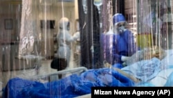 A medic treats a patient infected with coronavirus at a hospital in Tehran on March 1.