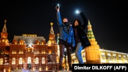 Young people turn on the flashlights of their mobile phones in support of jailed opposition politician Aleksei Navalny near Red Square in Moscow on February 14.