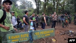 Indonesian soldiers and other members of a search-and-rescue team at the location of the Russian Sukhoi Superjet's crash in Cidahu.