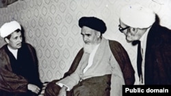 Akbar Hashemi Rafsanjani (left) and Supreme Leader Ruhollah Khomeini (center) in an undated photo