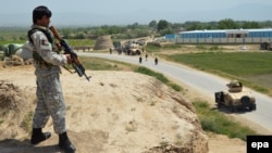 An Afghan security officer takes position during an ongoing battle with the Taliban in Kunduz on May 3.