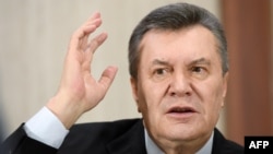 Former Ukrainian President Viktor Yanukovych gestures as he answers journalists questions during a press conference in Moscow in February.