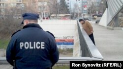 Members of the Kosovo Police Force stand guard on the central bridge in Mitrovica.