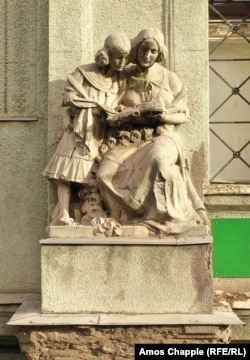 A moment of learning is captured in a sculpture atop a girls elementary school built in 1913 alongside the Danube in northern Budapest.