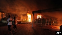 A vehicle and surrounding buildings burn after they were set on fire inside the U.S. Consulate compound in Benghazi, Libya, on September 11.