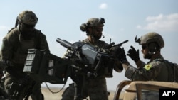 Men in uniform identified by Syrian Democratic forces as U.S. Special Operations Forces ride in the back of a pickup truck in the village of Fatisah in the northern Syrian province of Raqa, on May 25.