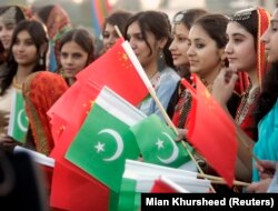 People hold Chinese and Pakistani flags ahead of a state visit.