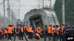 Workers prepare to remove a derailed car of the Nevsky Express.