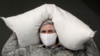 An employee wearing a protective mask, used as a measure against the coronavirus, carries a bag with flour at a bakery in the city of Nevinnomyssk in the Stavropol region on March 27.