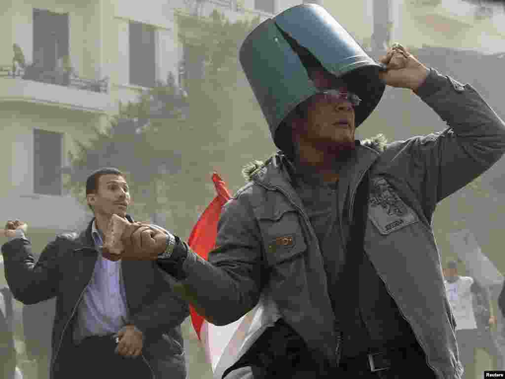 A protester throws a rock near Tahrir Square on the 10th day of demonstrations.