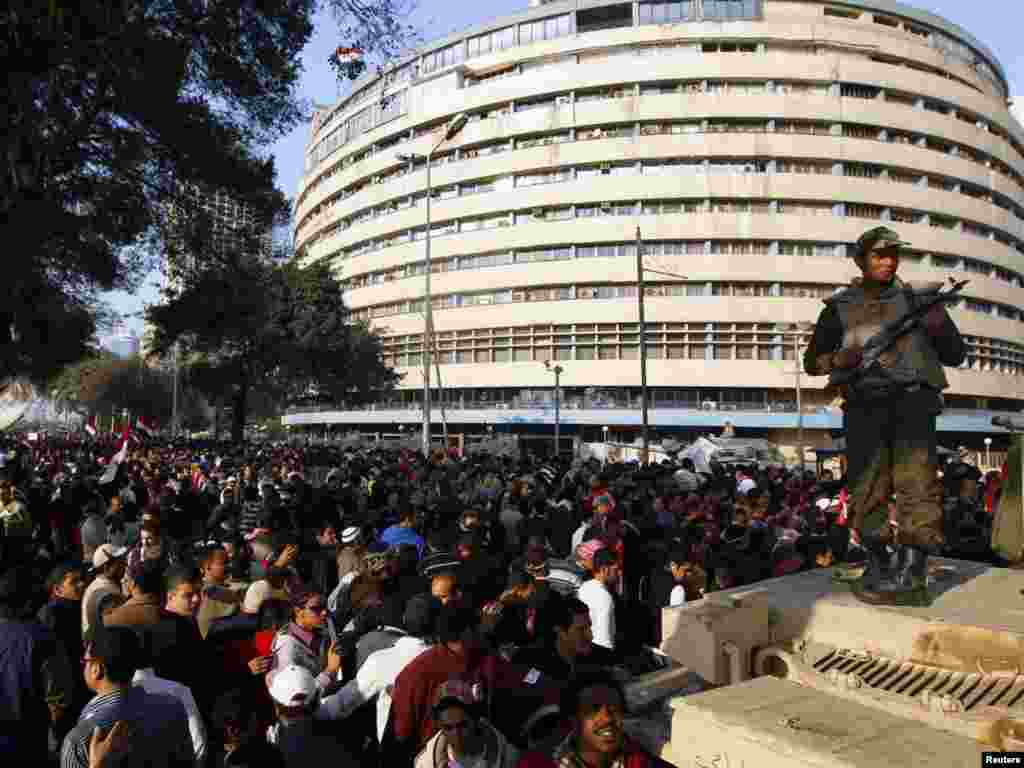 A soldier stands atop a tank guarding the state TV building on the Corniche in Cairo on February 11.