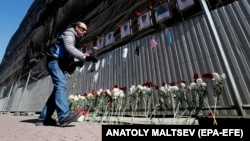 A man lays flowers and pays tribute to medical workers who have died from COVID-19 at a makeshift memorial in front of the local health department in St. Petersburg, Russia.