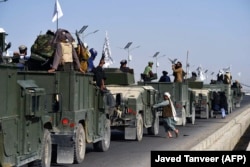 Celebrating Taliban troops ride in a convoy of captured Humvees in Kandahar on September 1.