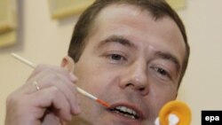 Medvedev paints a traditional Russian clay toy at the Kirov regional art museum