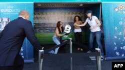 Femen activists make their move with the Euro 2012 trophy on display in the Ukrainian city of Dnipropetrovsk on May 21.