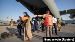 Evacuees from Afghanistan leave a German Air Force plane in Tashkent on August 26.