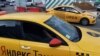 An Uber car (back) and a Yandex.Taxi car on the streets of Moscow in July.