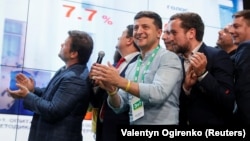 Ukrainian President Volodymyr Zelenskiy (center) reacts at his party's headquarters in Kyiv as parliamentary results come in on July 21. 