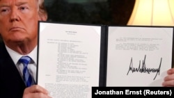 U.S. President Donald Trump holds up a proclamation declaring his intention to withdraw from the Iran nuclear agreement after signing it in the Diplomatic Room at the White House in Washington on May 8.