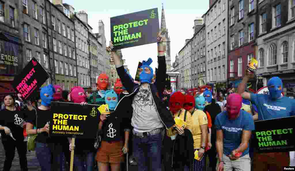 Protesters wearing masks take part in an Amnesty International flash-mob demonstration in support of Pussy Riot in Edinburgh on August 14.