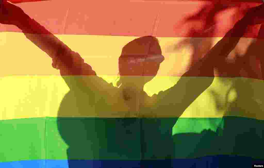 The shadow of a gay-rights activist is seen behind a flag as she takes part in the march.&nbsp;