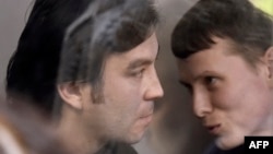 Yevgeny Yerofeyev (left) and Aleksandr Aleksandrov talk to each other in a glass cage in a Kyiv courtroom where they were sentenced on terrorism charges on Aporil 18. 