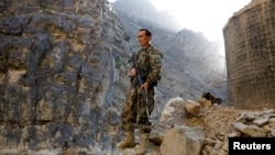 An Afghan government soldier stands guard on the Jalalabad-Kabul highway on July 8 amid recent gains made by the Taliban. 