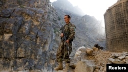 An Afghan government soldier stands guard on the Jalalabad-Kabul highway on July 8 amid recent gains made by the Taliban. 