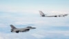 A Norwegian F-16 jet fighter (left) tracks a Russian Tupolev Tu-95 strategic bomber earlier this year. In 2014, there was a marked increase in the number of times NATO aircraft intercepted Russian planes probing alliance defenses.