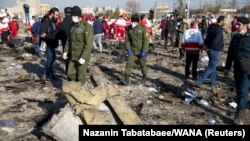 Security officers and Red Crescent workers inspect the site where the Ukraine International Airlines Flight PS752 crashed after takeoff from Iran's Imam Khomeini Airport on the outskirts of Tehran on January 8, 2020. 