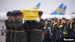 Soldiers carry a coffin containing the remains of one of the 11 Ukrainian victims of the Ukraine International Airlines Flight 752 plane disaster during a memorial ceremony at the Boryspil International Airport outside Kyiv on January 19.