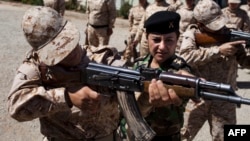 Captain Kwestan Mohammed Ali instructs female Peshmerga recruits how to hold an AK-47 near the northern Iraqi city of Sulaimaniya on September 10.