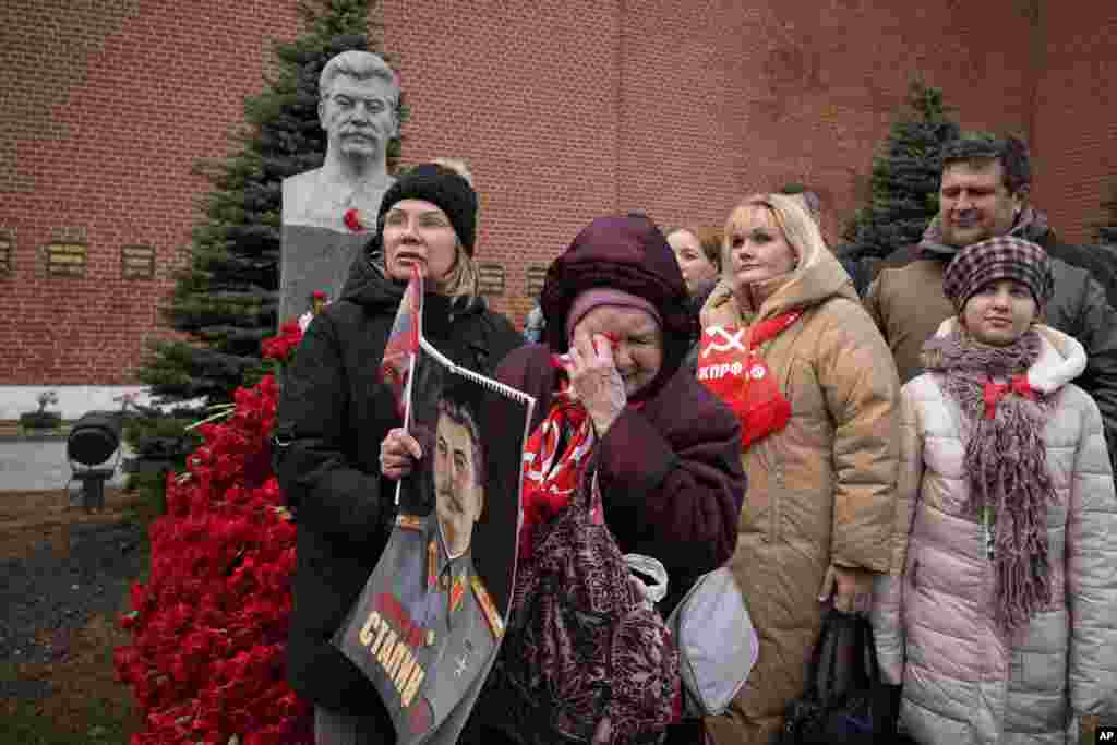 A woman cries holding a portrait of Soviet leader Joseph Stalin after laying flowers at his grave near the Kremlin Wall to mark the 72nd anniversary of his death, on Red Square, Moscow, on March 5.