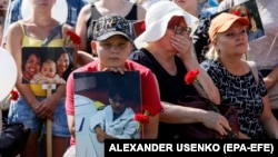 Local people hold portraits of lost passengers during a mourning ceremony at the MH17 crash site on the seventh anniversary of the disaster near the separatist-controlled village of Hrabove on July 17.