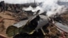 People stand next to the wreckage of an Indian Air Force's helicopter after it crashed in Budgam district. some 30 kilometers from Srinagar on February 27. 