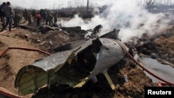 People stand next to the wreckage of an Indian Air Force's helicopter after it crashed in Budgam district. some 30 kilometers from Srinagar on February 27. 