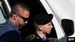 U.S. Army Private First Class Bradley Manning (right) is escorted by military police as arrives to hear the verdict in his military trial at Fort George G. Meade, Maryland on July 30.