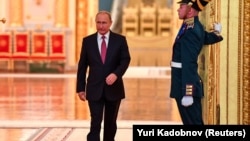 Russian President Vladimir Putin walks past an honor guard as he attends a ceremony at the Kremlin in Moscow.