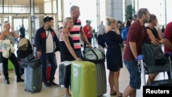 Tourists wait in line to try to catch flights home at the airport in Sharm el-Sheikh after finishing their holidays in the Red Sea resort.