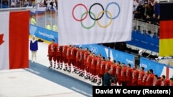 Olympic ice hockey players from Russia wear their gold medals under the Olympic flag during the 2018 Winter Olympics in Pyeongchang.