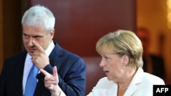 Serbian President Boris Tadic and German Chancellor Angela Merkel arrive at a joint news conference after their meeting in Belgrade.