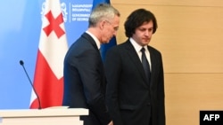 Georgian Prime Minister Irakli Kobakhidze (right) and NATO Secretary-General Jens Stoltenberg leave talks in Tbilisi on March 18.