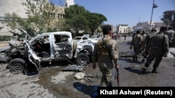 Free Syrian Army fighters inspect damaged cars after a car bomb in Azaz, Syria, in September 2018. 