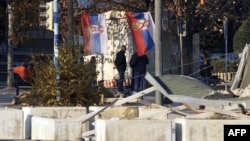 Ethnic Serbs stand in front of a barricade in the divided town of Mitrovica, in northern Kosovo.