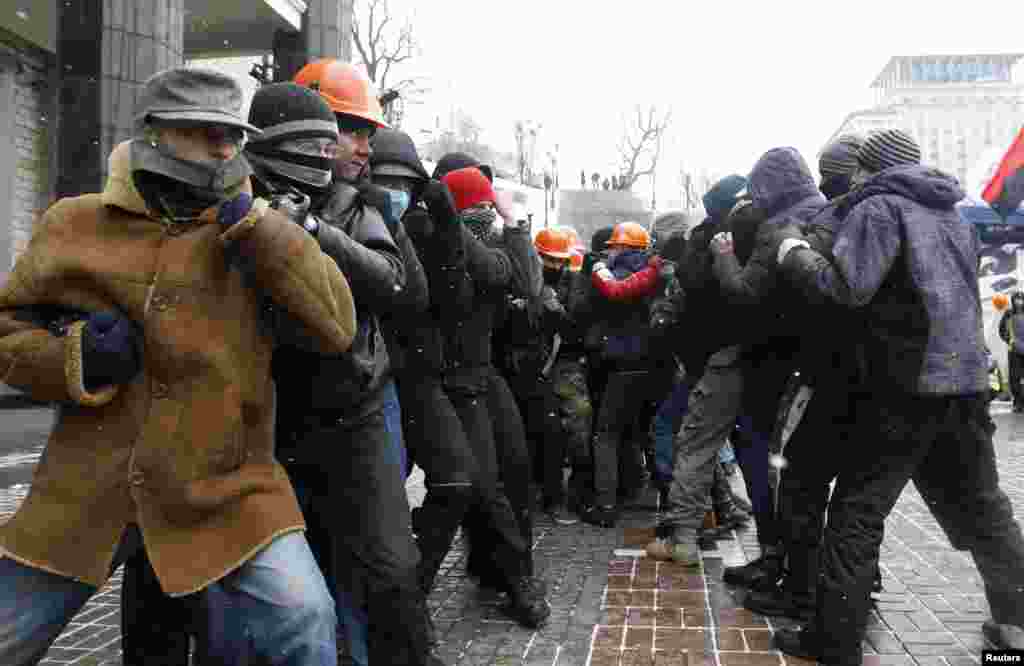 Protesters practise tactics to defend themselves from possible police scuffles during a rally held by supporters of EU integration in central Kyiv on December 8.