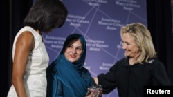 First Lady Michelle Obama (left) and U.S. Secretary of State Hillary Clinton (right) congratulate Shad Begum of Pakistan during the U.S. State Department's 2012 International Women of Courage Award winners' ceremony on March 8.