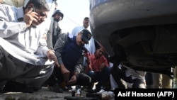 Pakistani investigators look at the belongings of attackers including grenades outside the Chinese Consulate after an attack in Karachi on November 23.