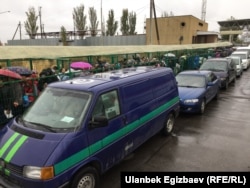 People and vehicles lining up along the Kyrgyz-Kazakh border.